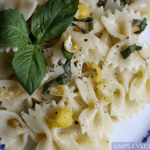 lemon pepper pasta plated on blue china with basil leaves