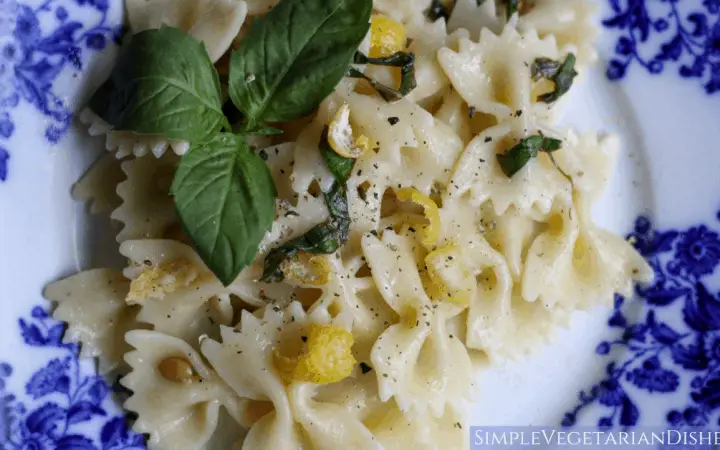 lemon pepper pasta plated on blue china with basil leaves