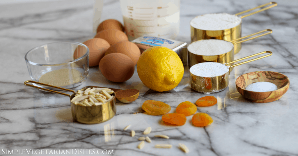 dried apricots, slivered almonds, lemon, yeast, cinnamon, salt, eggs, butter, milk, flour, sugar, powdered sugar on marble table