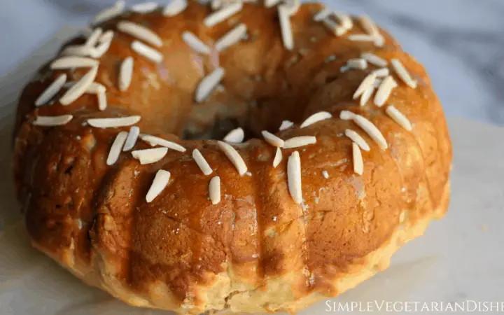 bobka bundt with lemon glaze topped with slivered almonds on marble serving board