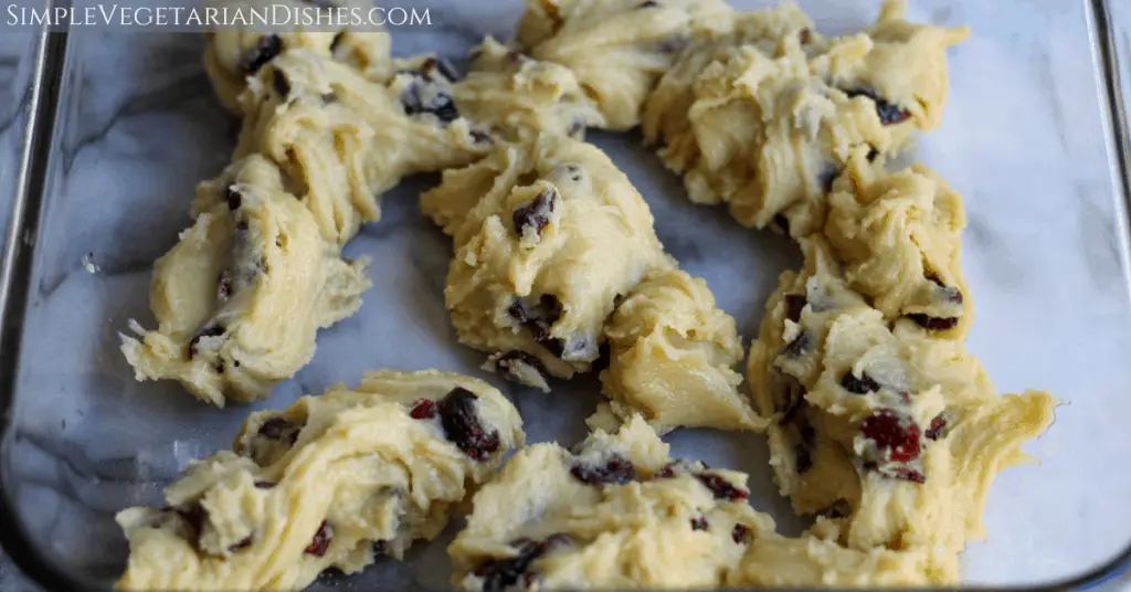 spoonfuls of cranberry cookie dough on bottom of glass pan