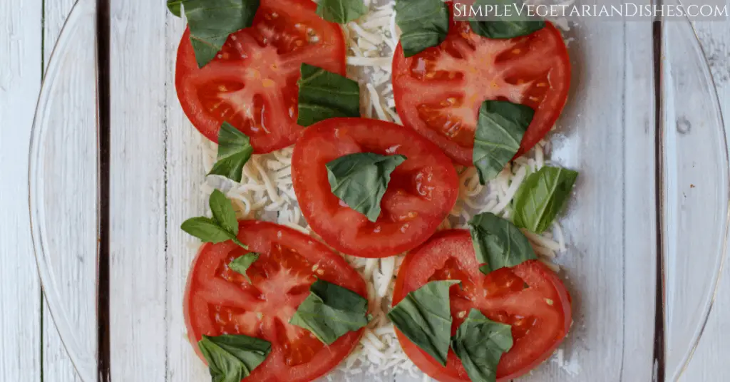 first layer with cheese, tomato slices, and fresh basil