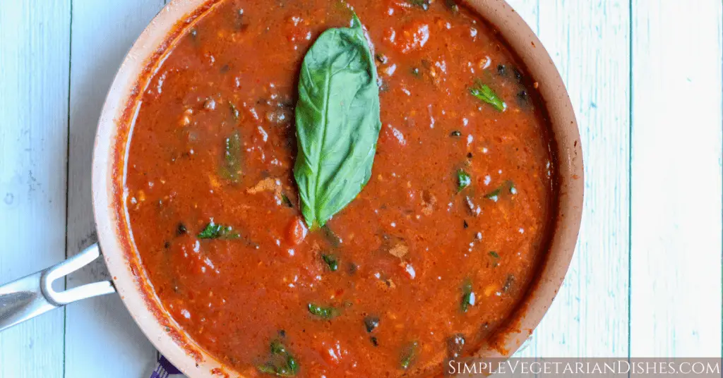 hearty marinara sauce in skillet with basil leaf