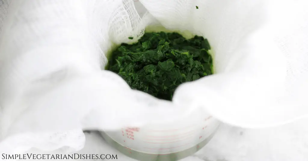 spinach strained through cheesecloth into measuring cup