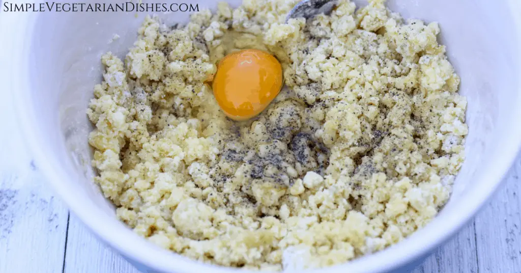 kartoffel klosse mixture with egg yolk and black pepper in mixing bowl