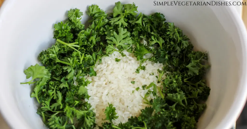large mixing bowl of white rice and fresh chopped parsley