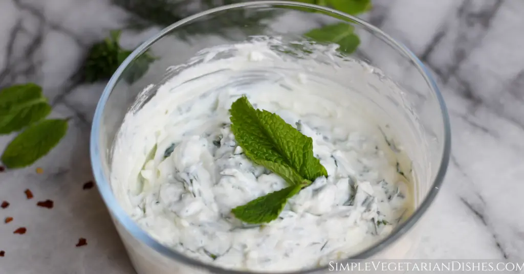 haydari Turkish yogurt dip served in glass bowl with fresh mint leaves as a garnish
