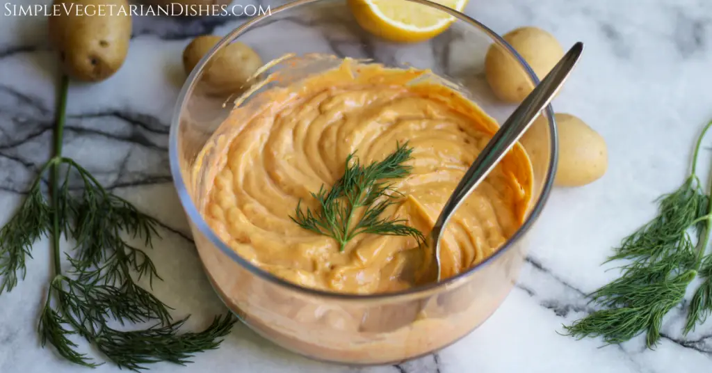 harissa aioli in glass bowl garnished with fresh dill