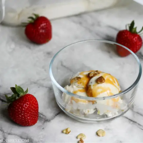black walnut ice cream served with caramel sauce and strawberries