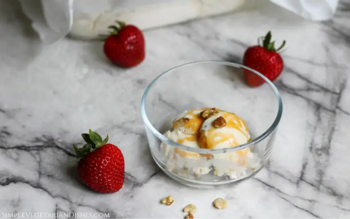black walnut ice cream served with caramel sauce and strawberries