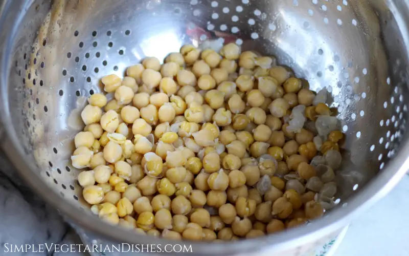 chickpeas for hommus in stainless steel colander after boiling with baking soda so skins have separated