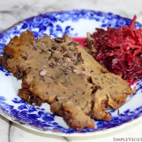 vegan corned beef served with red beet and cabbage kraut on blue china