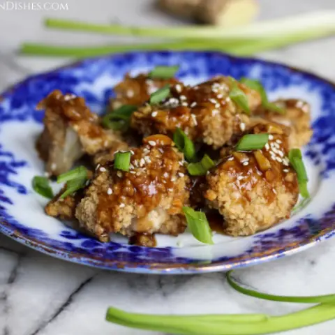 teriyaki cauliflower wings garnished with sesame seeds and green onions