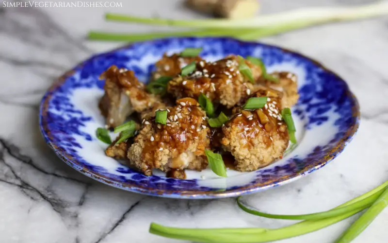 teriyaki cauliflower wings garnished with sesame seeds and green onions