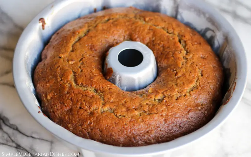 fig bread cooling in bundt pan on white marble table