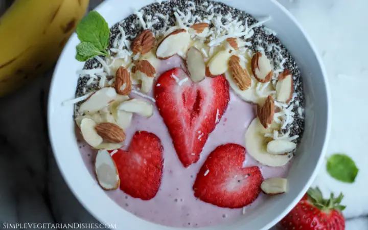 strawberry banana smoothie bowl with coconut, almonds, chia seeds, and mint