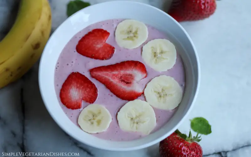 strawberry banana smoothie bowl with fresh cut fruit slices