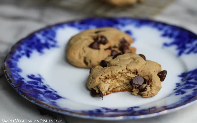 high altitude chocolate chip cookies served on blue china with bite missing