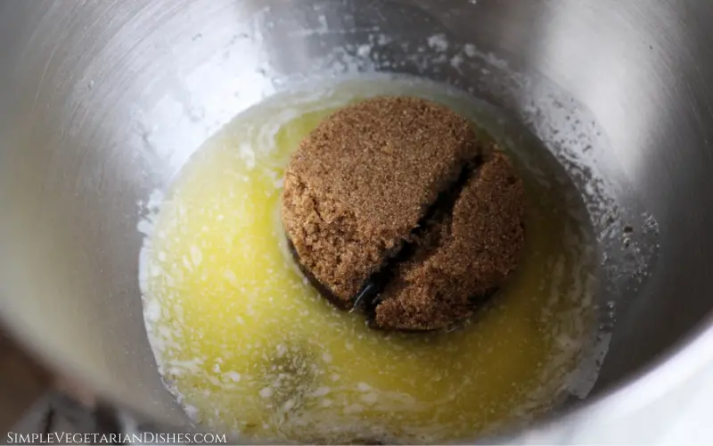 melted butter and scoop of brown sugar in stainless steel mixing bowl