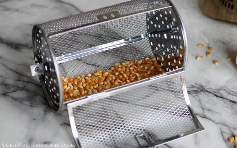 popcorn kernels in rotating mesh basket ready for the air fryer