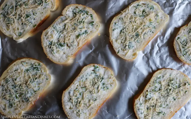 vegan garlic bread ready to bake on foil lined baking sheet