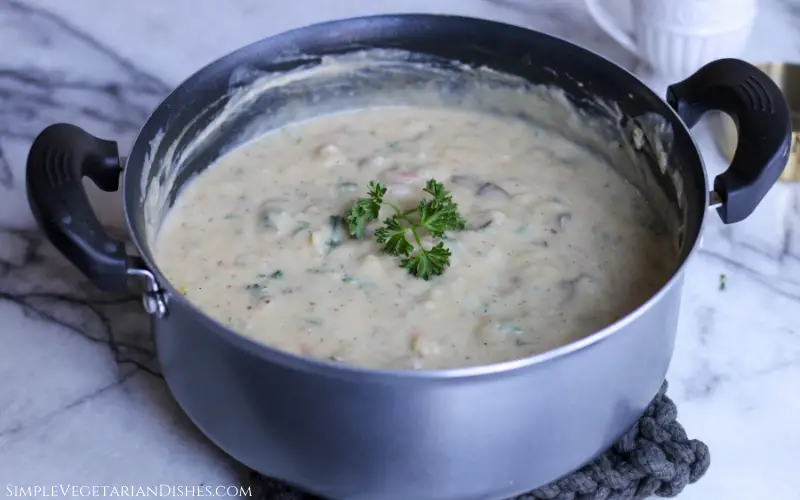 German potato soup done in silver Dutch oven with sprig of parsley