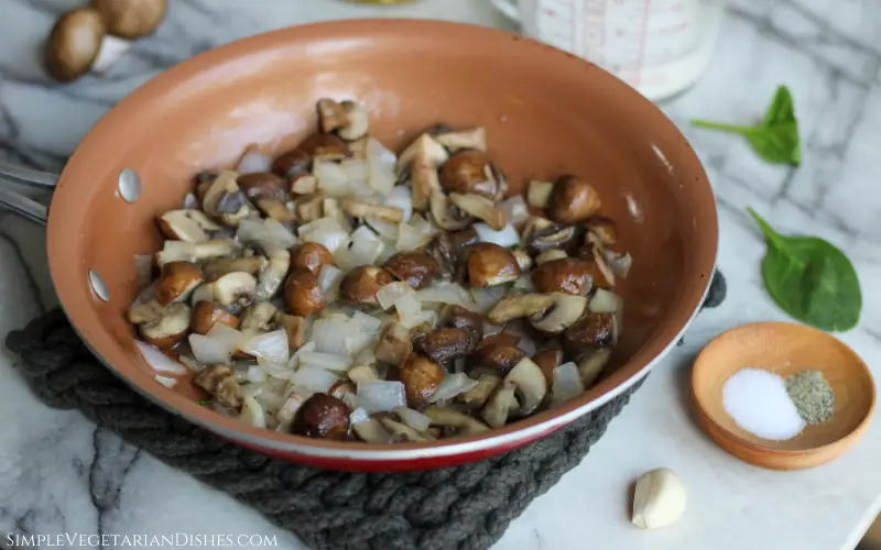 sautéed cremini mushrooms and onion in copper skillet