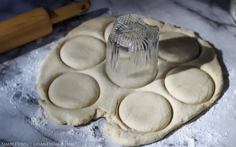 cutting out rolled out dough with glass