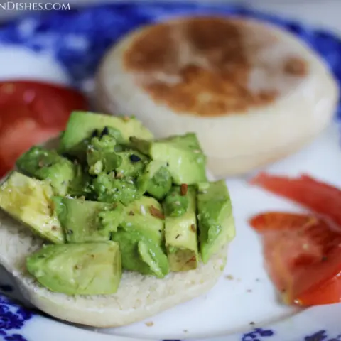 vegan English muffin avocado toast with tomatoes on blue china