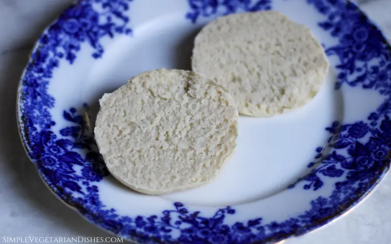 vegan English muffin cut in half on blue china