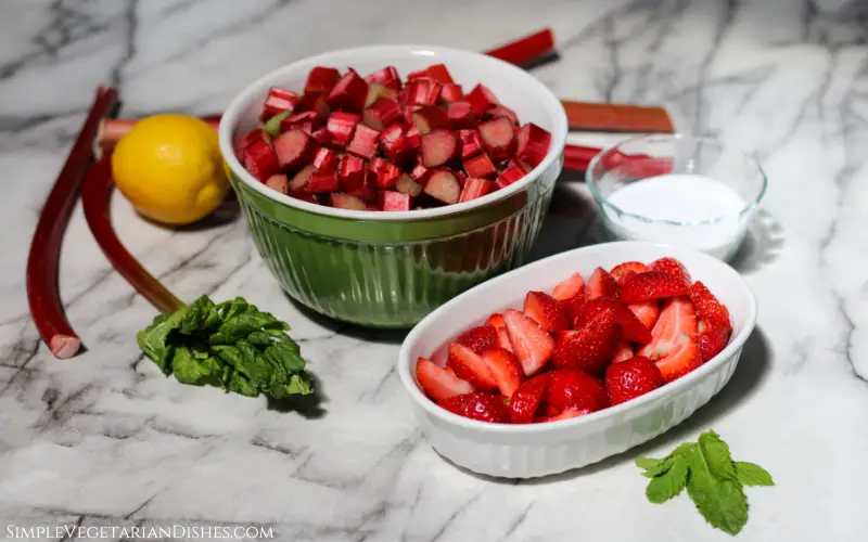 chopped fruit/berries in bowls with sugar, lemon, and mint