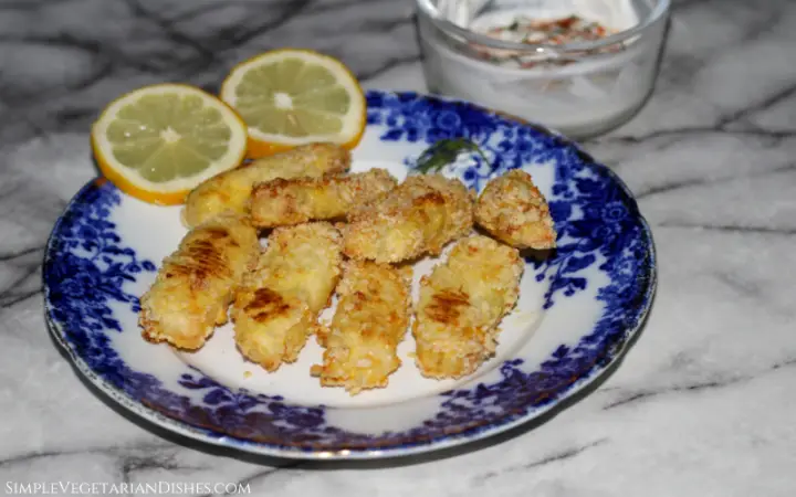 baked halloumi fries served on blue china plate with lemon slices and yogurt dip