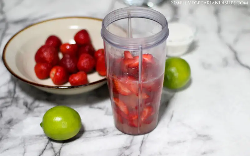 sliced strawberries in lime juice in blender to make strawberry limeade