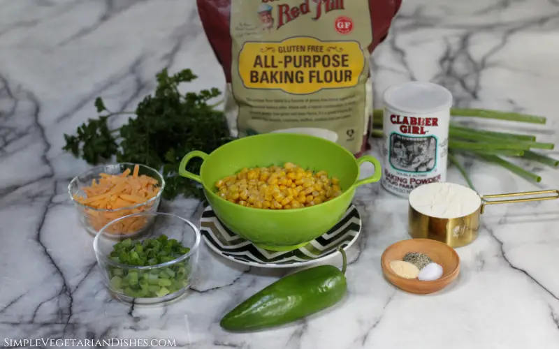 corn, jalapeno, green onion, cheddar, parsley, gluten-free flour, baking powder and spices on white marble table