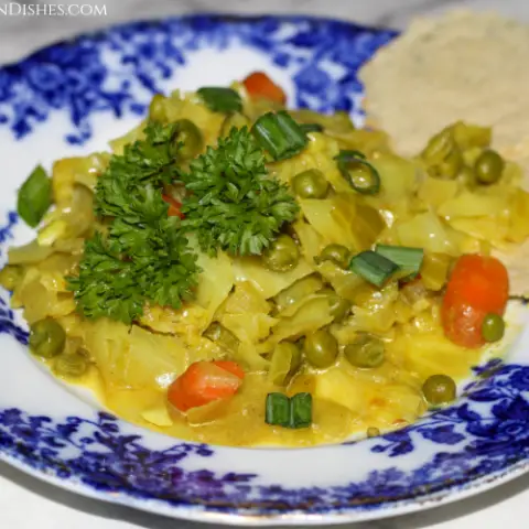 cabbage curry served on blue china with parsley garnish