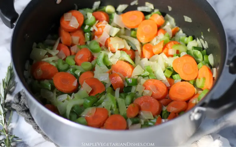 Dutch oven with sautéed onion, carrots, celery, leeks, and garlic