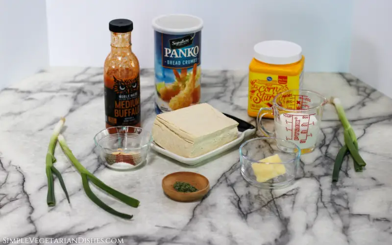 ingredients to make baked buffalo tofu wings on white marble table