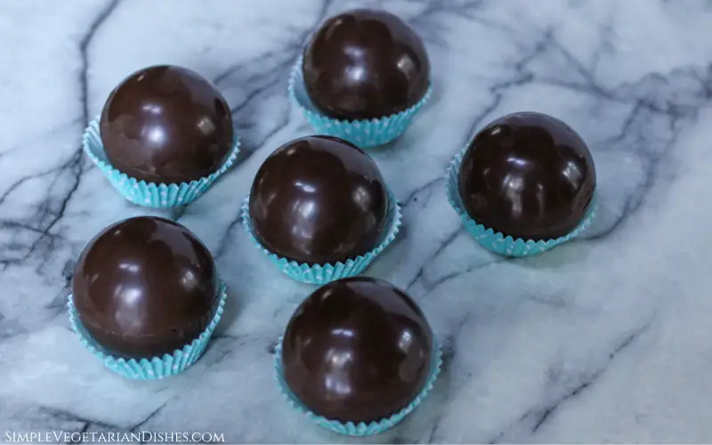 six vegan hot chocolate bombs in blue cupcake liners