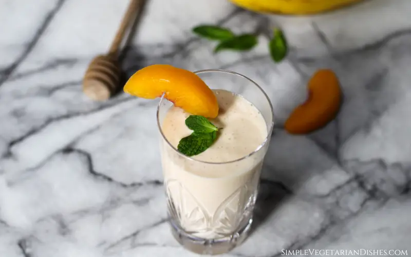 banana peach smoothie served in crystal glass