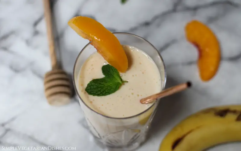 banana peach smoothie served with copper straw