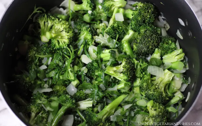 sautéed vegetables broccoli arugula onions in black pot