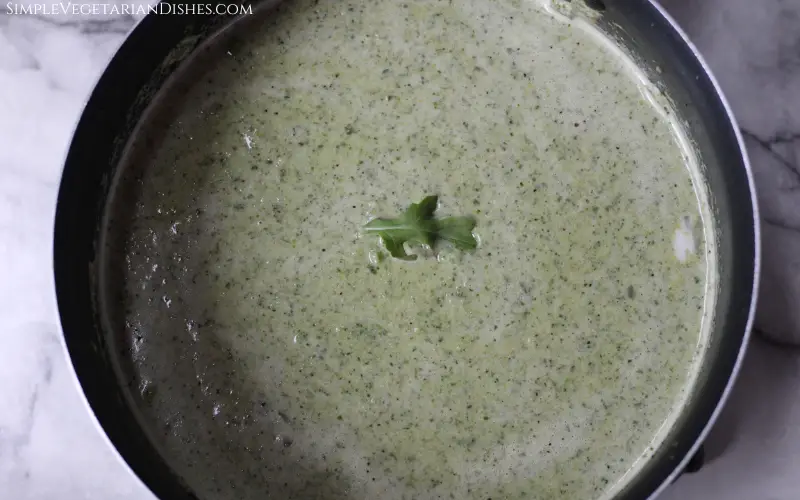 black pot of green goddess soup with arugula leaf