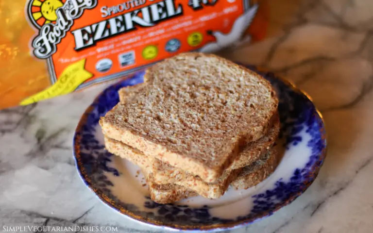 is Ezekiel bread keto image of four slices of bread stacked on blue china plate with loaf in background