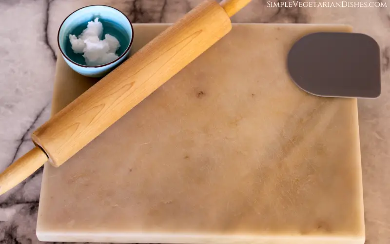 marble cutting board, rolling pin, dough scraper and coconut oil