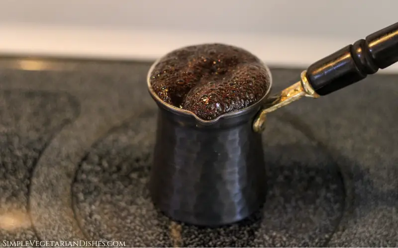 small pot cezve or ibrik bubbling on stove