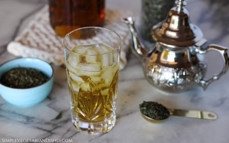 health benefits of nettle tea image glass of iced nettle tea with teapot in background